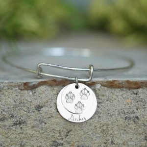 A double silver charm with paws. You can engrave it as you choose. Perfect for dog collars.