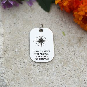 A silver charm with a compass and quote for Dad's.