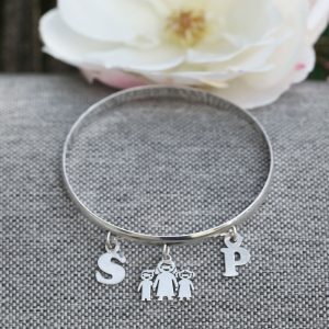 A 6mm wide rounded silver bangle with two initials and a mummy charm
